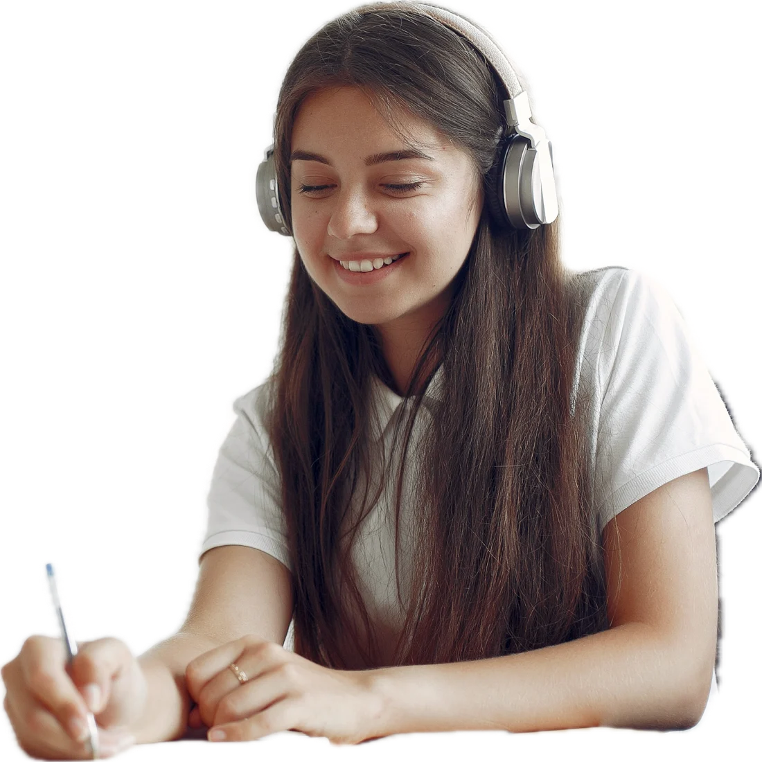 A girl in headphones smiling as she writes in a notebook.